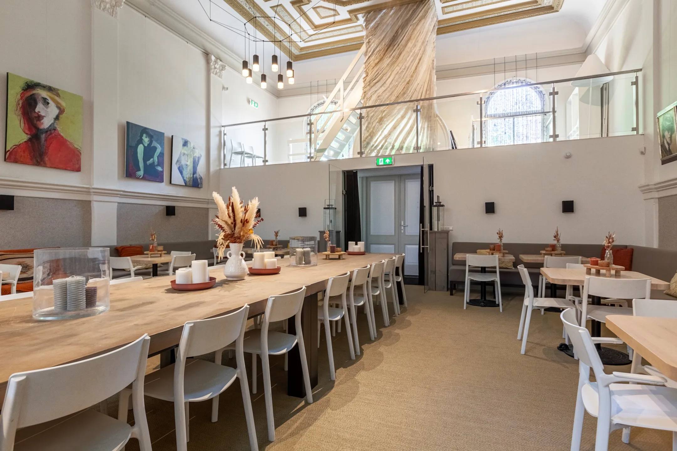 The hall set out with tables and chairs beneath the gallery.