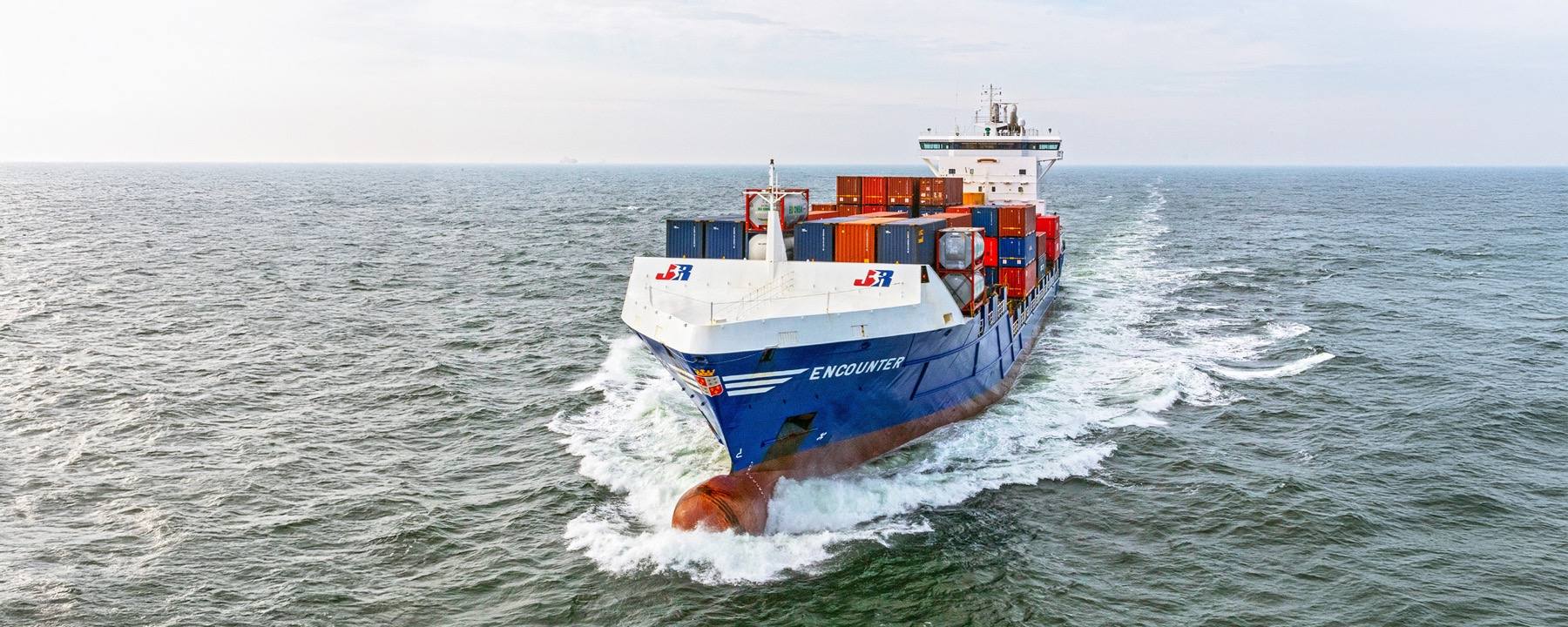 A JR Shipping container vessel under way at sea.