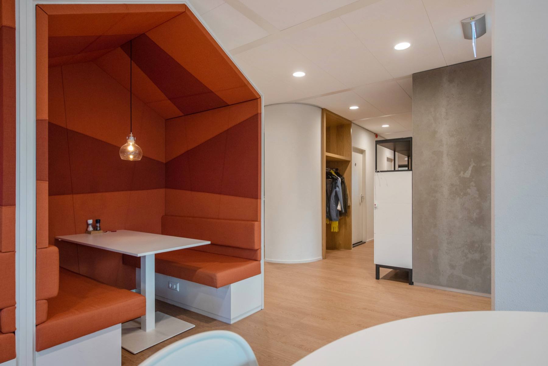 Een gestoffeerde zithoek naast het cafégedeelte van het gebouw.